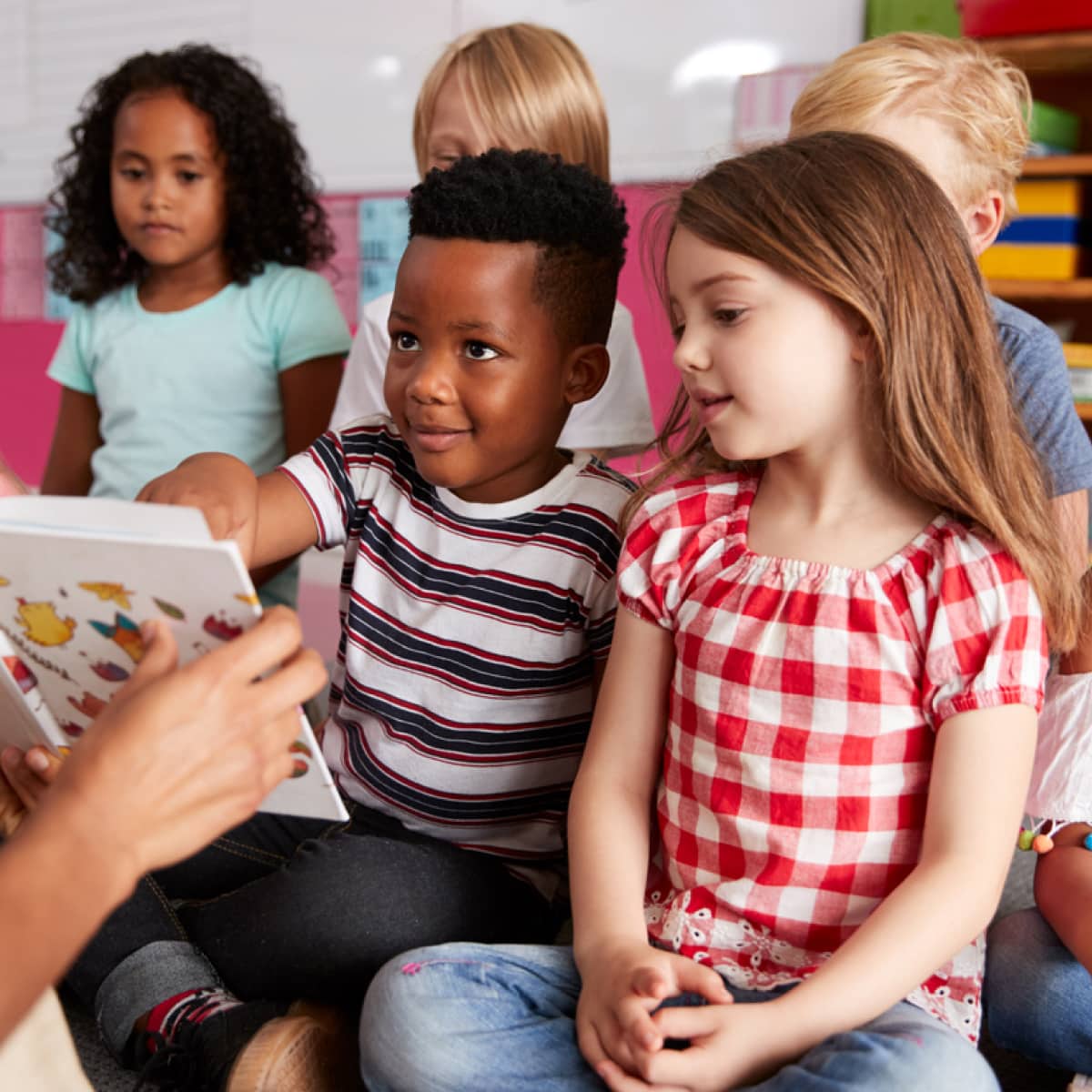 Multicultural school kids reading and studying books in library.
