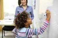 Student writing on white board