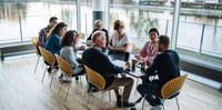 Team of people around a table having a conversation