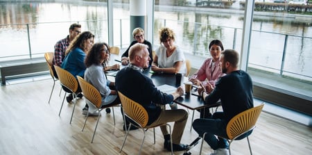 Team of people around a table having a conversation