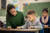 Child reading with a teacher