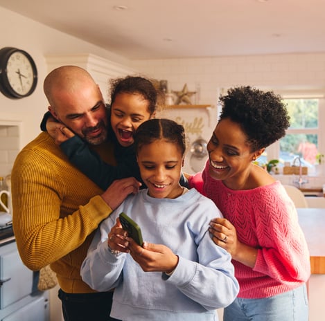 Family gathered looking at the daughter's phone