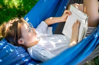 Girl reading a book in a hammock