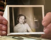 Adult holding an old 4th grade photo of themselves