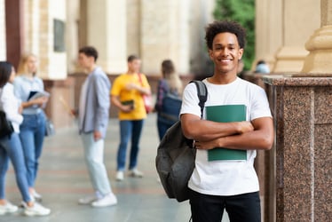 African American man holding books and smiling