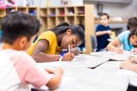 Students writing in a notebook