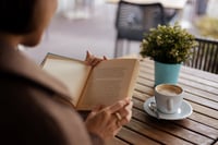 Woman reading a book at a coffee shop