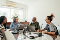 Small group of staff in a planning conversation with laptops open