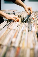 Someone flipping through vinyl records at a store