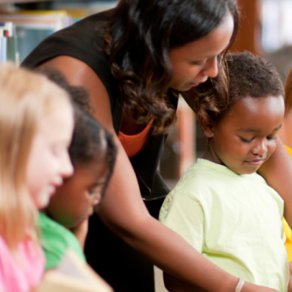 Teacher helping students read